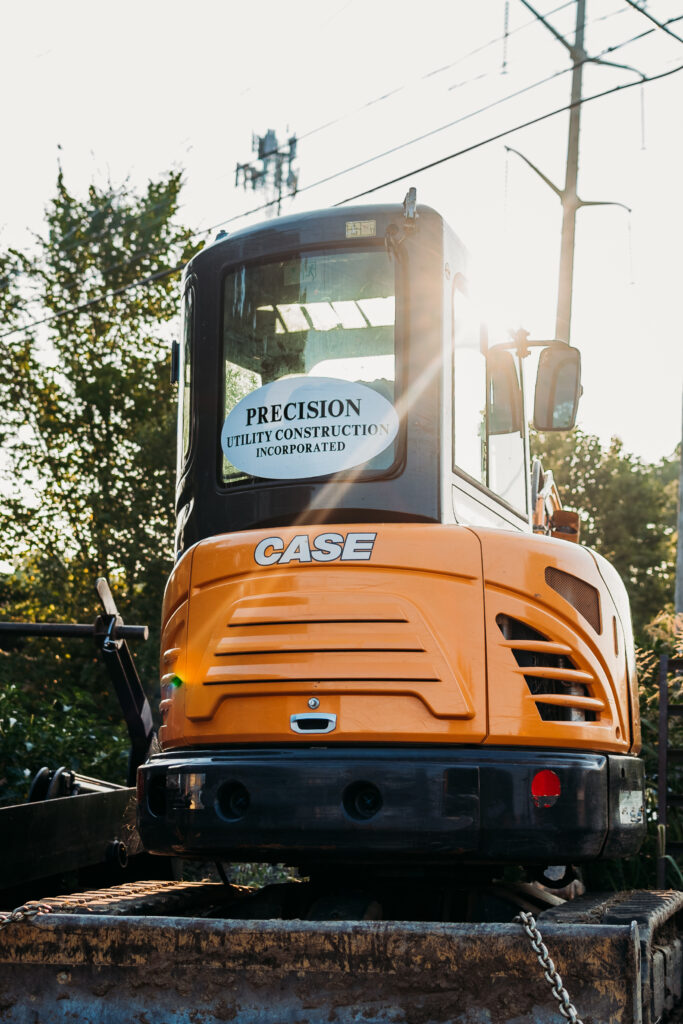 CASE excavator with Precision Utility Construction logo decal